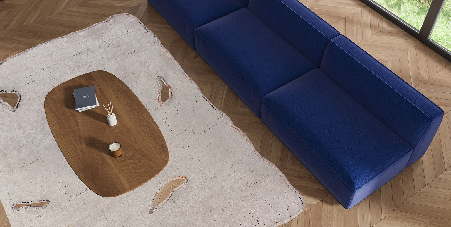 Picture of Amorph rug in living room with  a blue couch and coffee table.